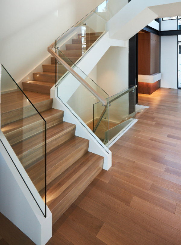 Tangga geometris dengan langkah-langkah terbuka dan railing kaca